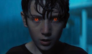Brightburn Brandon's eyes glowing in the middle of a rainstorm