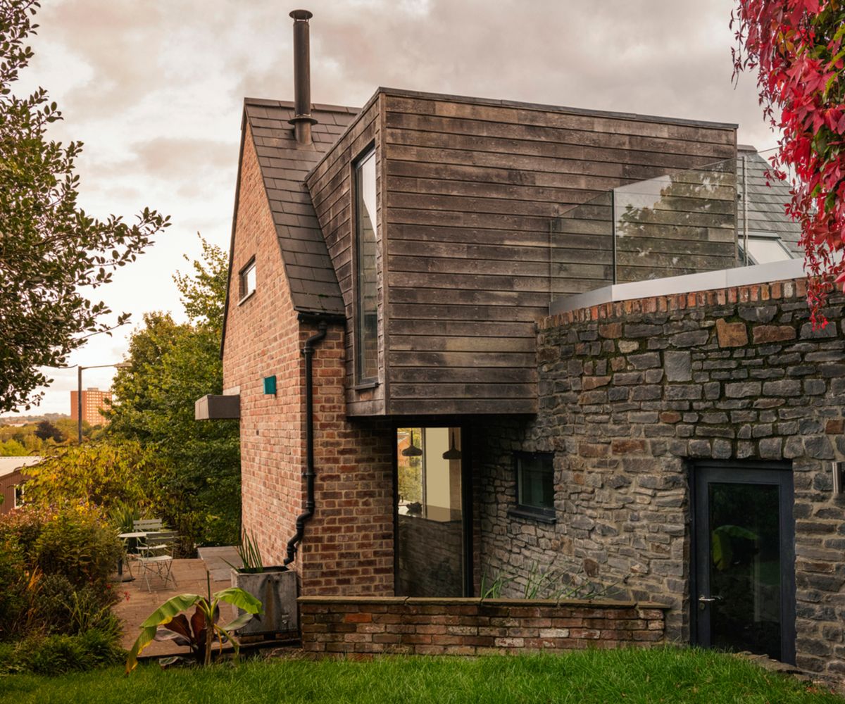 exterior of home with brick, stone wall and timber clad second floor extension