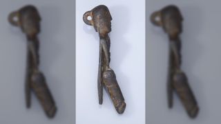The loop on the back suggests that it may have been worn as a phallic pendant on a necklace.