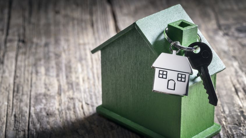 Green model house with keys hanging off of the chimney