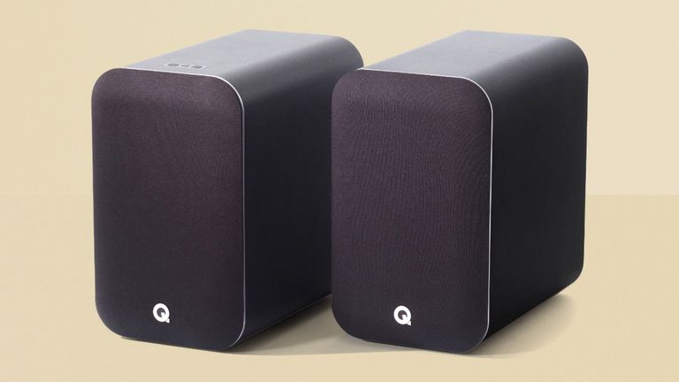 Q Acoustics M20 HD product, two black speakers sitting on a yellow background