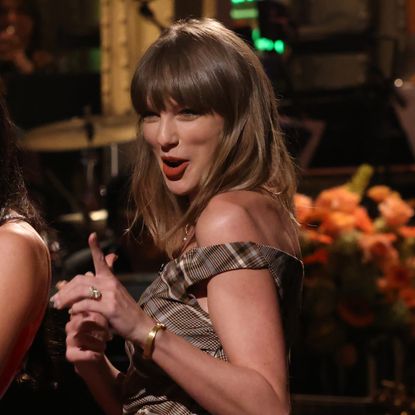 Taylor Swift appears on SNL wearing a plaid mini dress from Simkhai