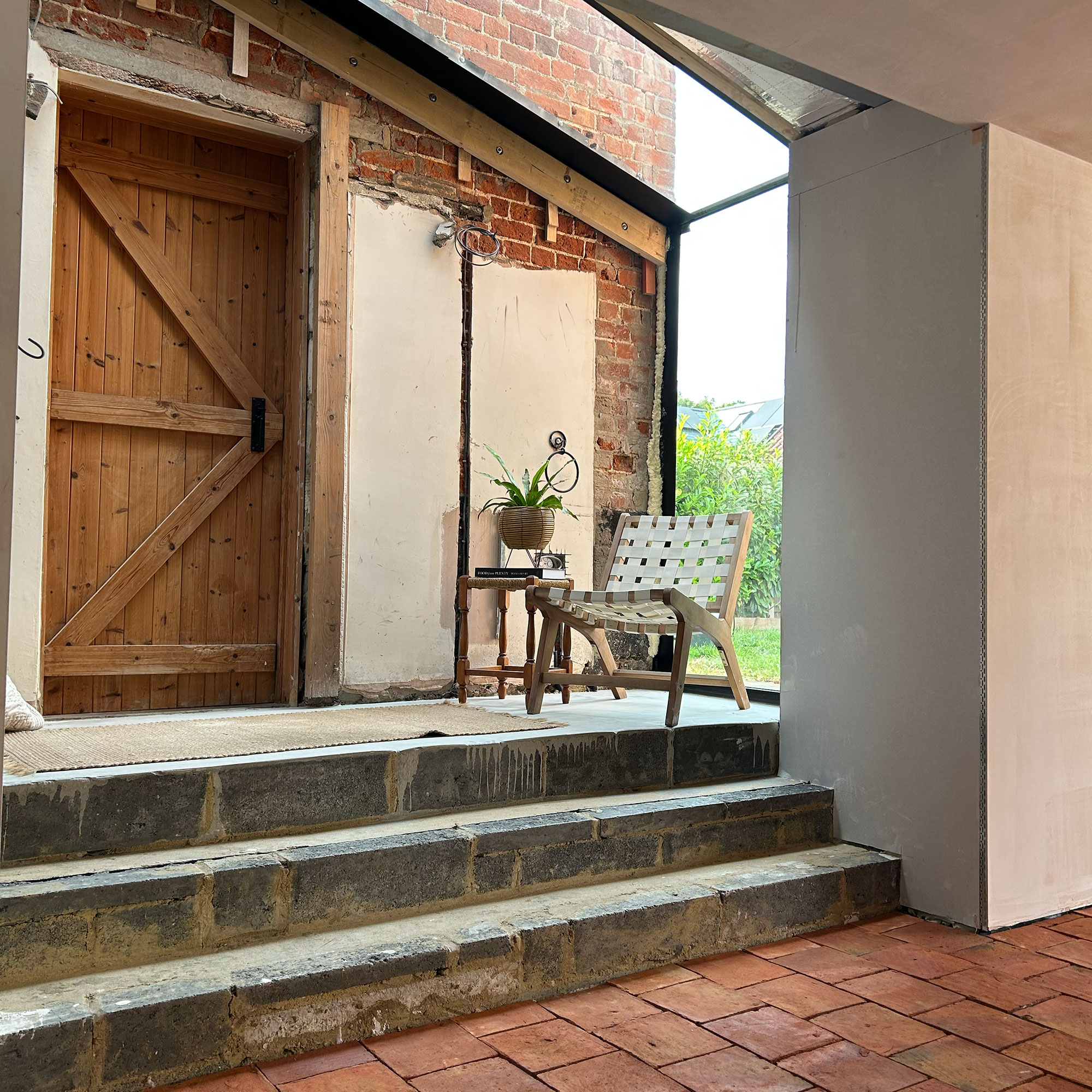 Concrete steps being built connecting extension in home