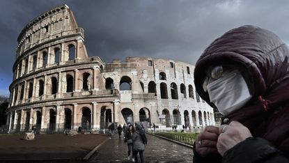 A masked visitor to the Colosseum in Rome