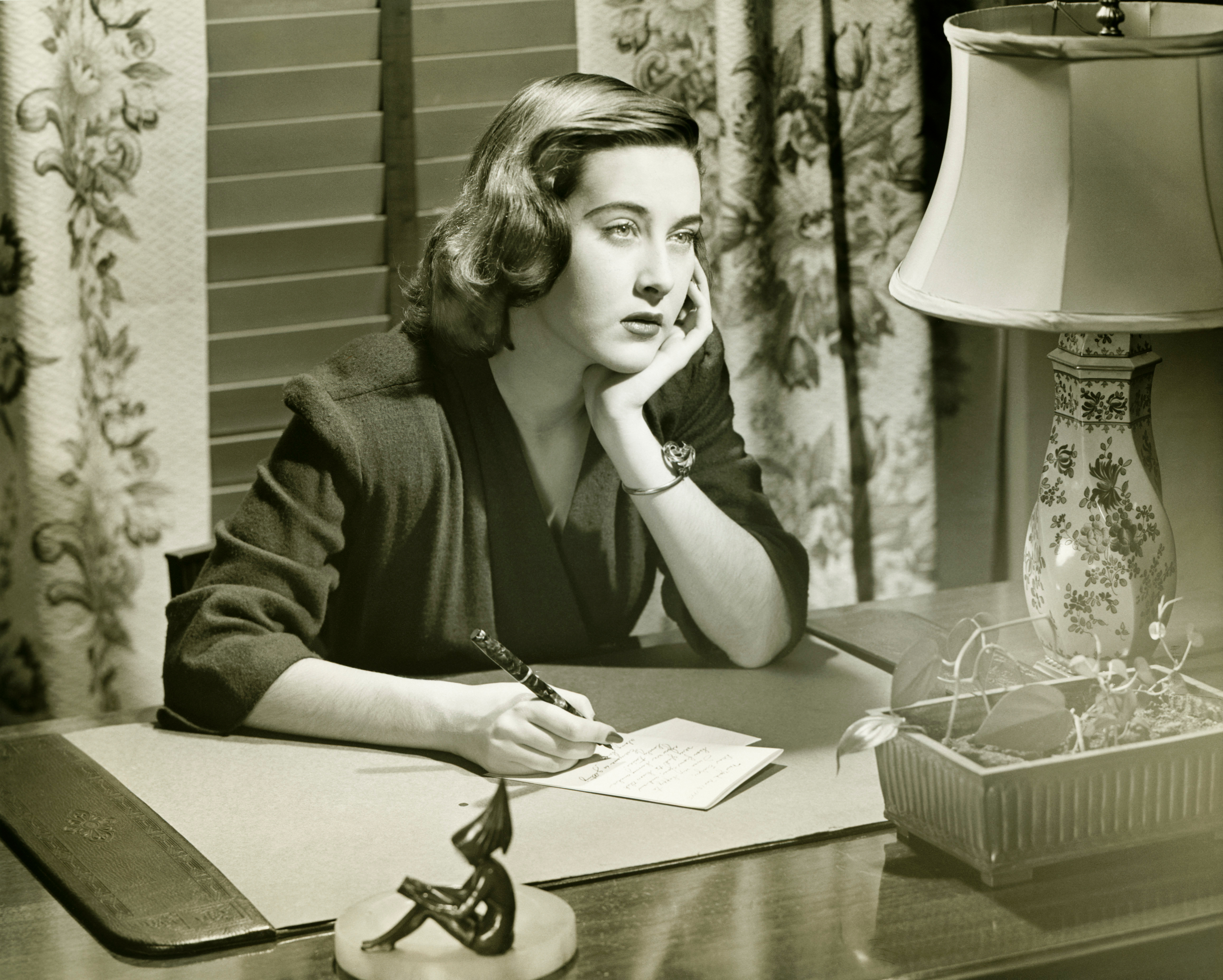 Sepia photograph of a woman writing a letter