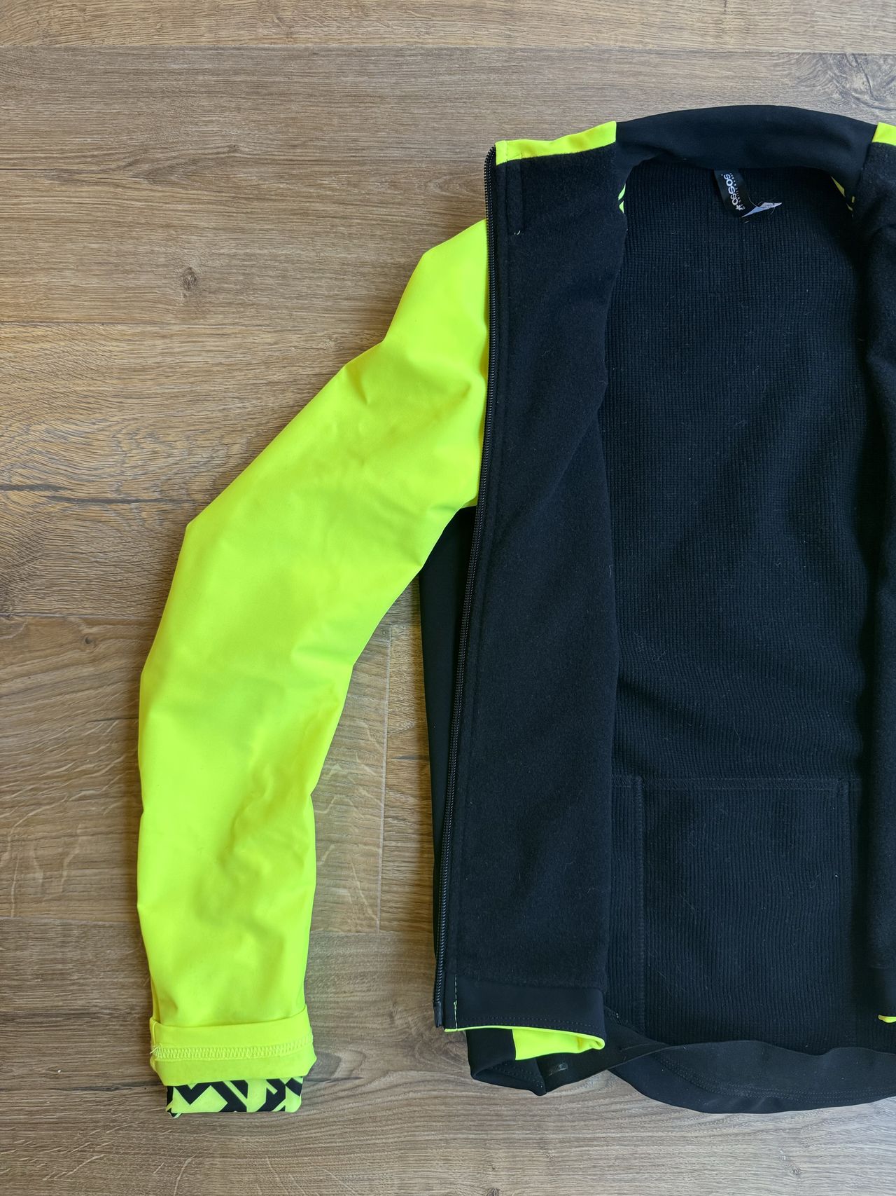 A flat flay of a black jacket with the inner showing a mix of fabrics including the RX on the front panels