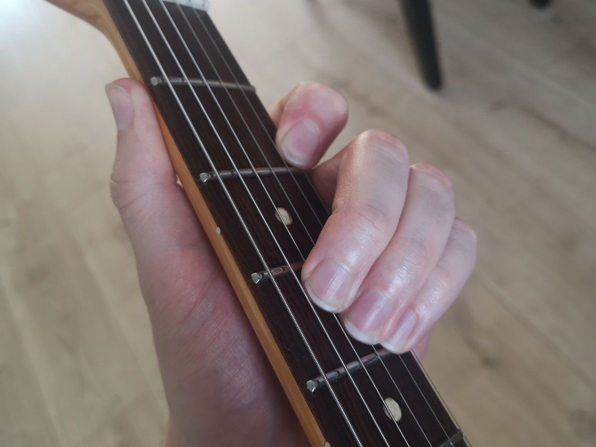 A demonstration of how to play a part of a B major barre chord on four strings