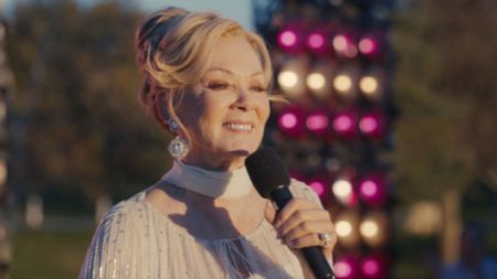 Deborah smiles as she talks on an outdoor stage