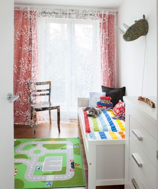 kids room with pink floral curtains and green play mat