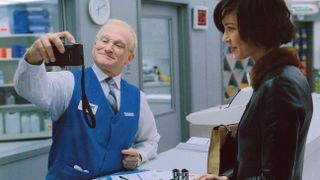 Robin Williams examines a camera in front of a customer