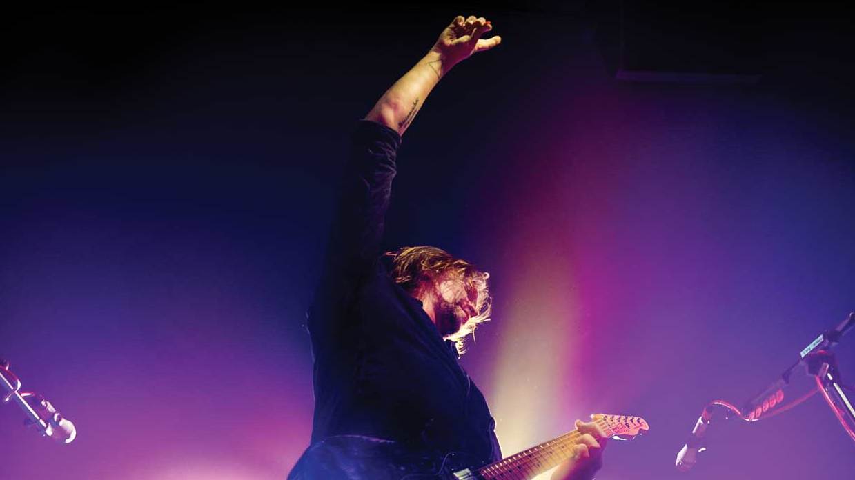 Frontman Mikko Von Hertzen playing guitar on stage