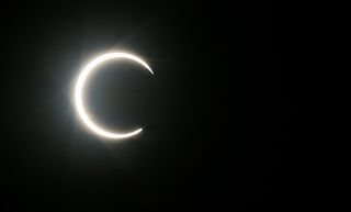 The moon partially covers the sun during an annular solar eclipse as seen in the Yemeni capital Sanaa, early on June 21, 2020.