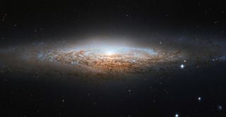 A view of a spiral galaxy seen nearly edge-on.