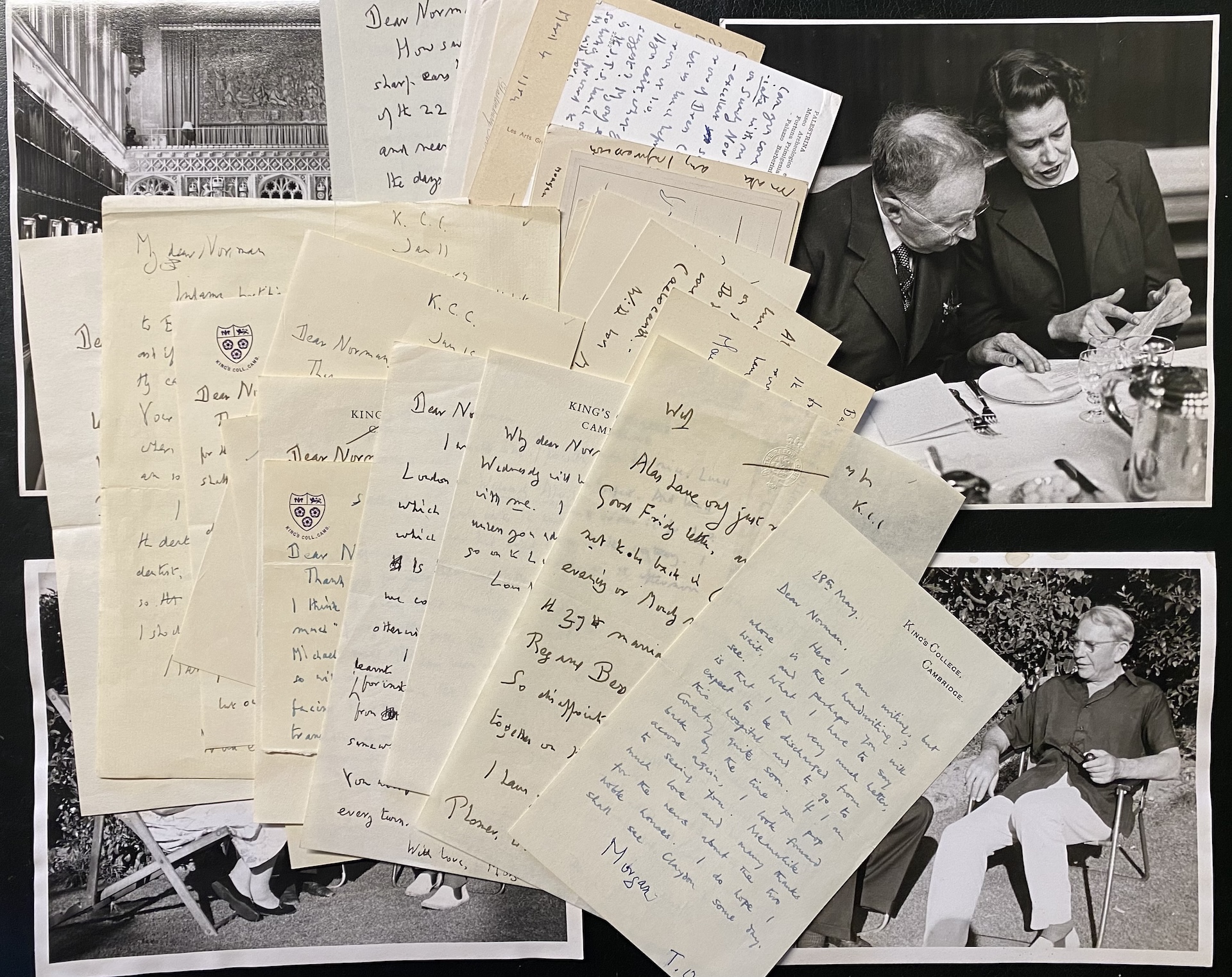 A photo of a messy pile of hand written letters on top of black and white photographs