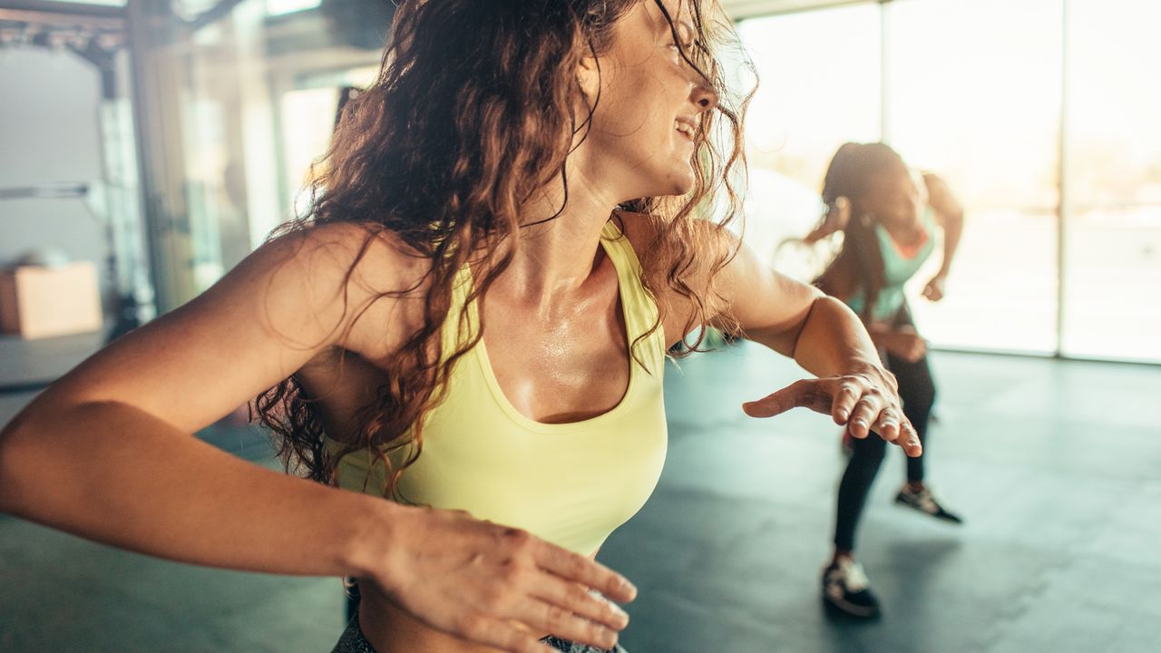 Group of women enjoying dance fitness. Selective focus on beautiful young woman dancing.