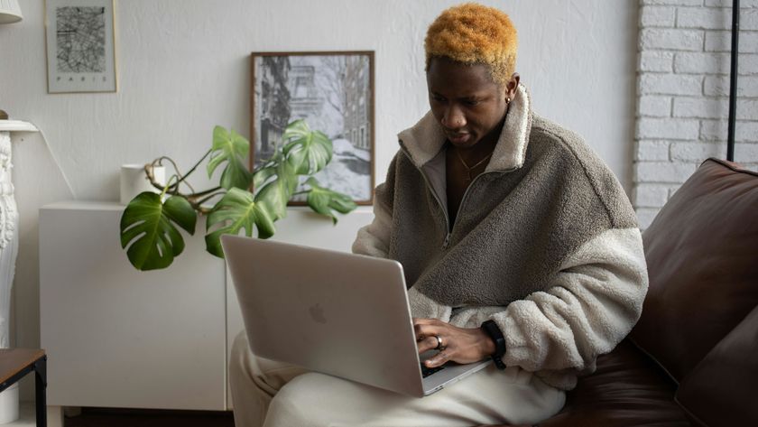 Person using a MacBook sat on sofa