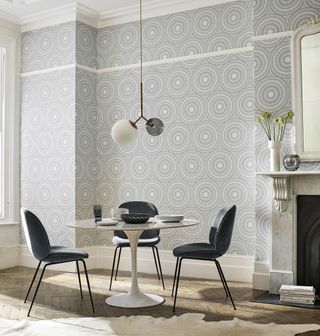 Cadencia round retro geometric grey wallpaper in living space with small round dining set and cream fireplace