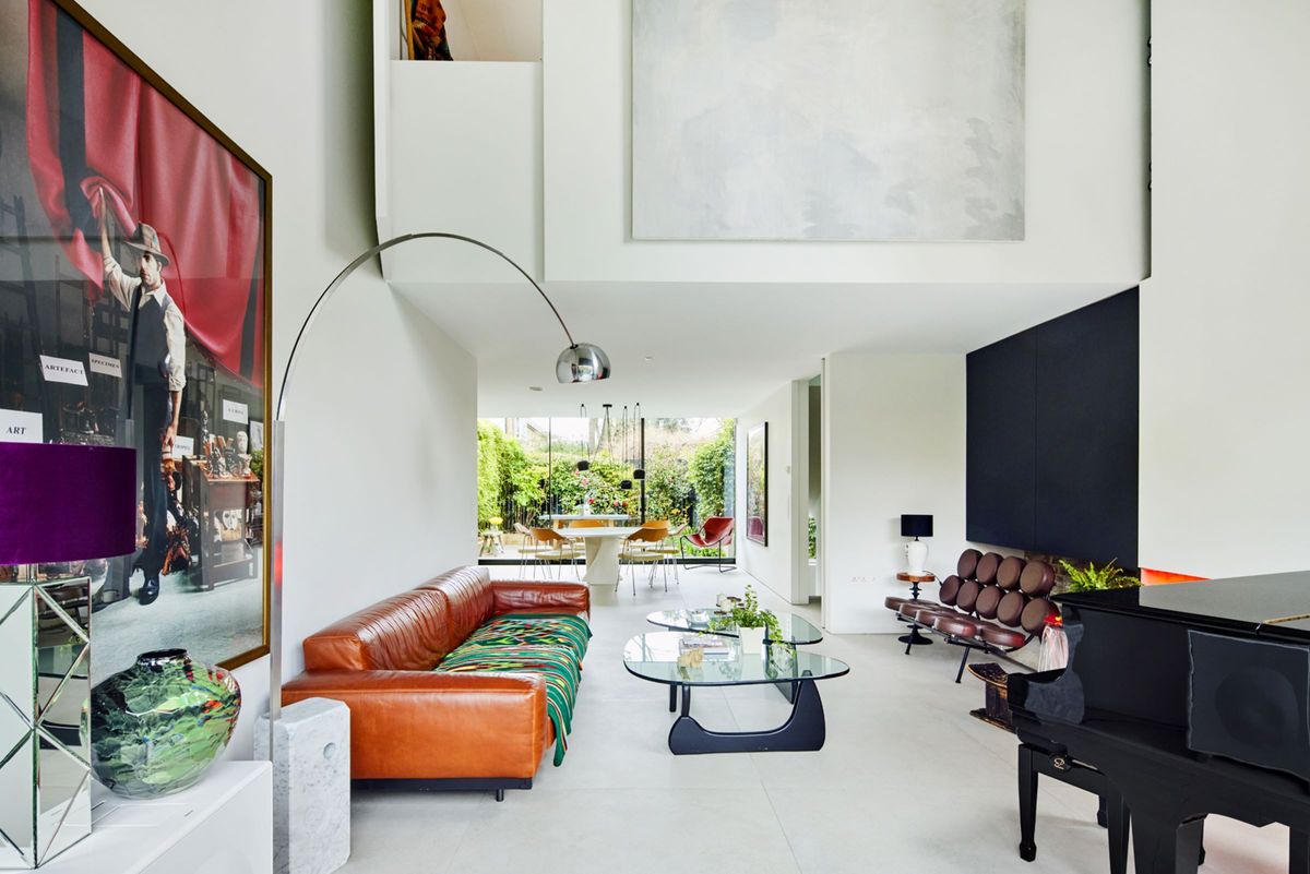 The living room leads into the kitchen and is brightly lit from the glass walls