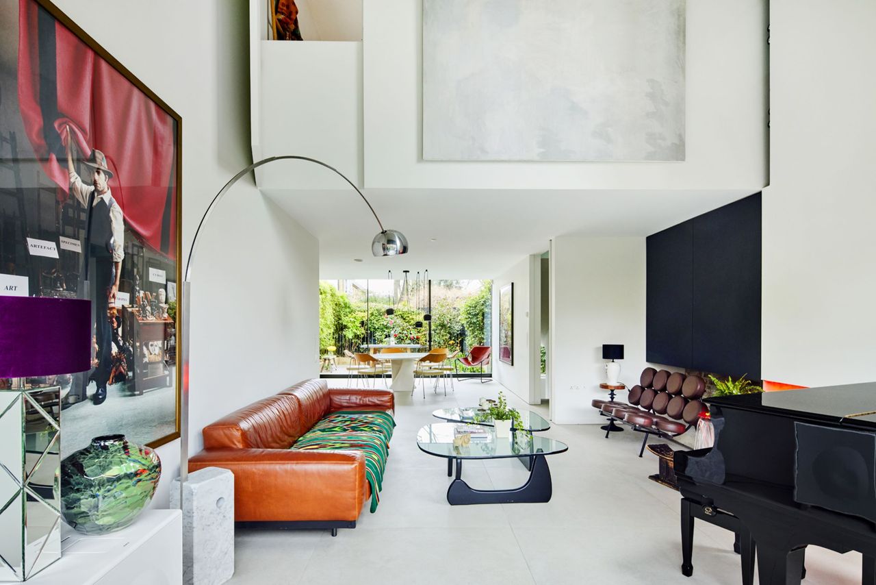 The living room leads into the kitchen and is brightly lit from the glass walls
