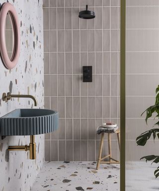 Beige bathroom idea with mocha gloss tiles, pink framed mirror and statement blue sink