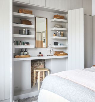 White bedroom with panelled wardrobes and hidden dressing table
