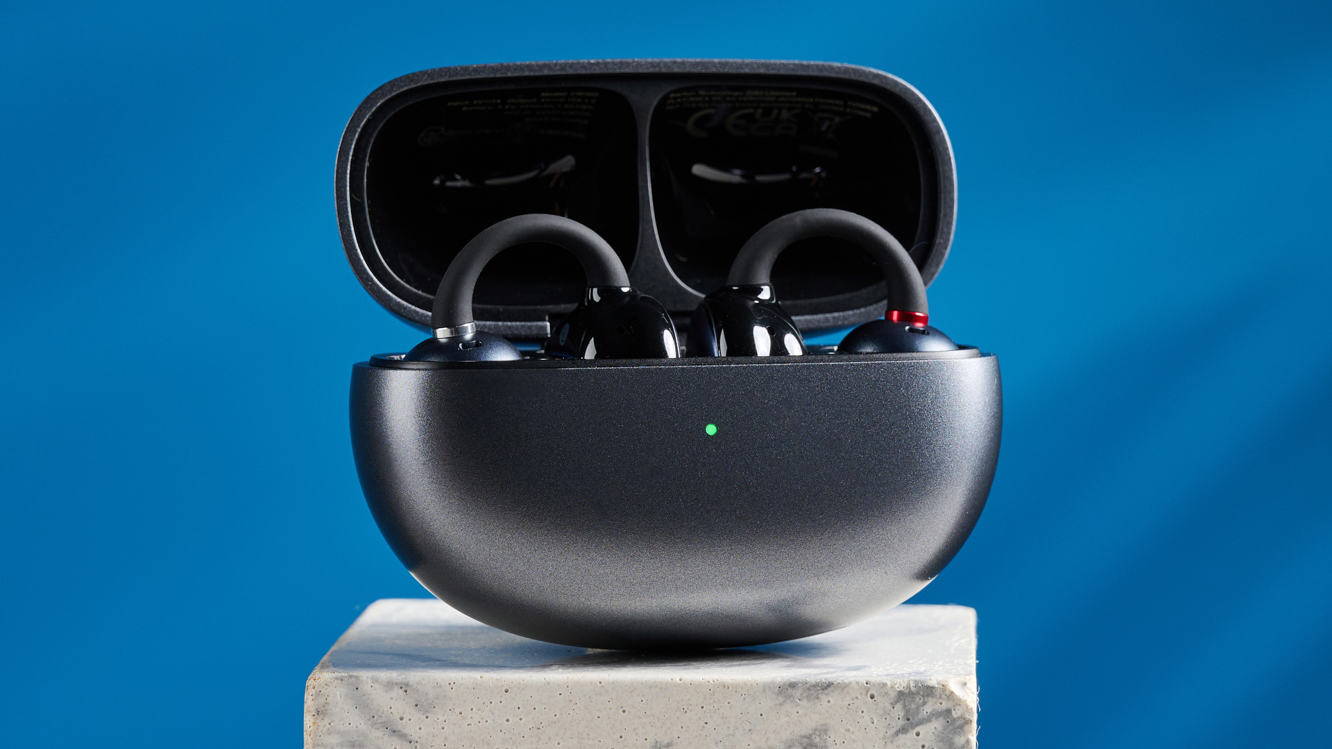 EarFun Clip open-earbuds photographed in front of a blue background.
