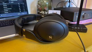 Sennheiser HD 620S headphones on desk in front of laptop with Chord and Cambridge DACs