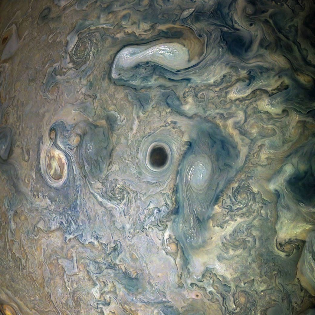 A dark-centered vortex in a jet stream on Jupiter can be seen alongside high-altitude clouds in this Juno image. This color-enhanced image was originally taken on May 29, 2019 and has since been finalized and named by citizen scientists Gerald Eichst&auml;dt and Se&aacute;n Doran.