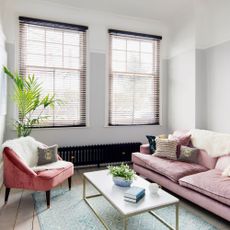 Light grey living room with pink velvet sofa and gold coffee table