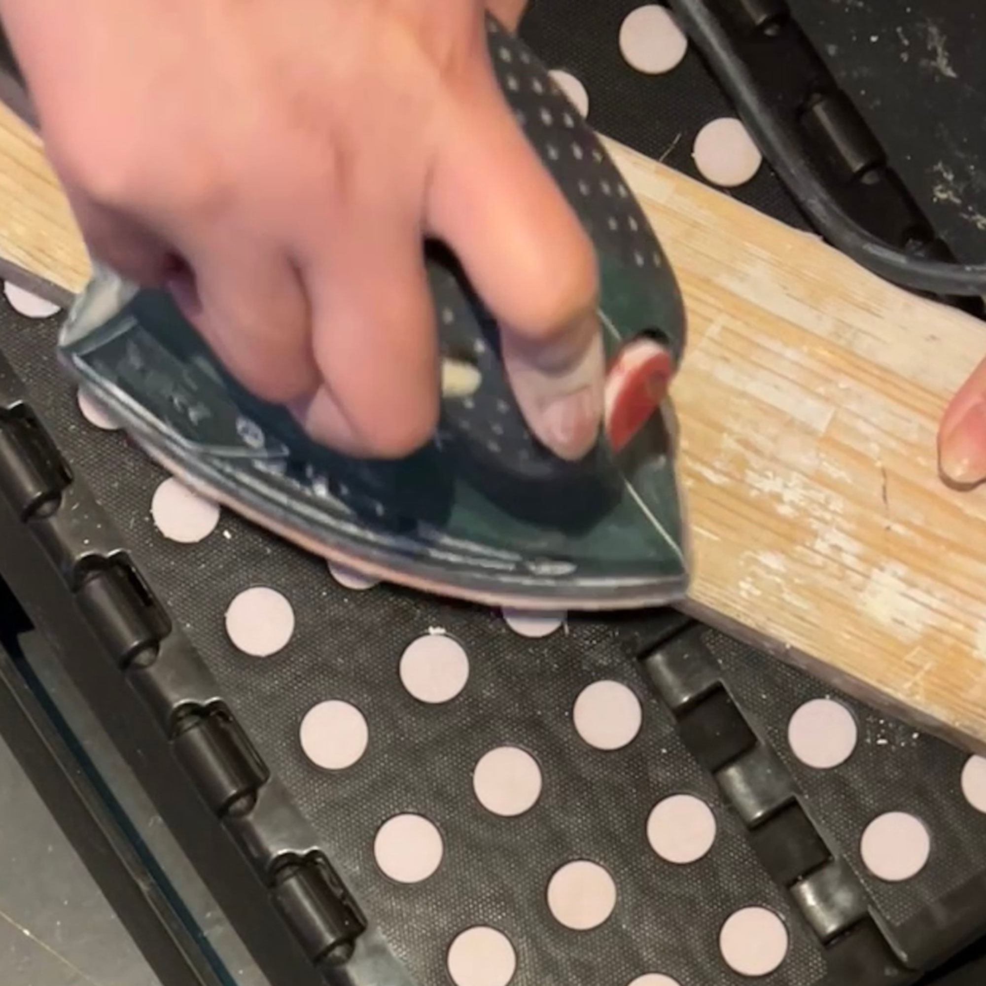 A sander being used on a plank of wood