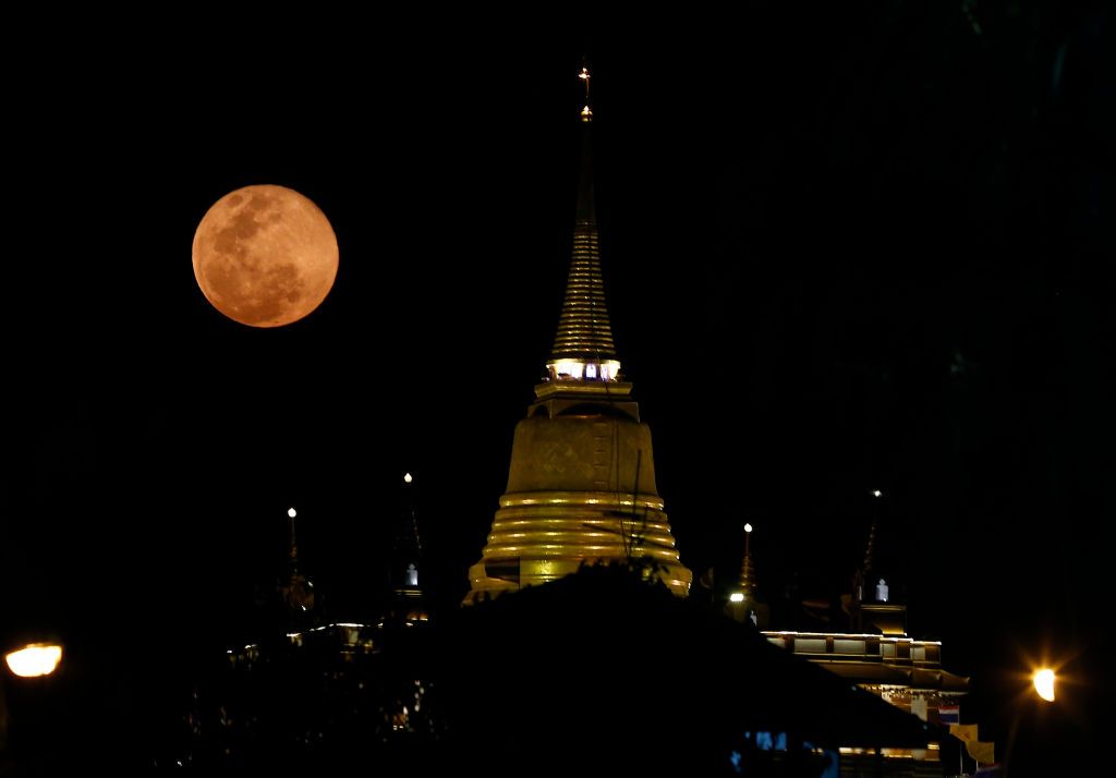 pink moon above a temple in Thailand.