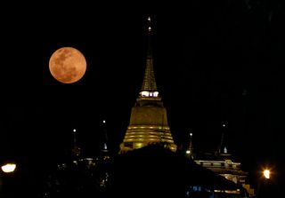 pink moon above a temple in Thailand.