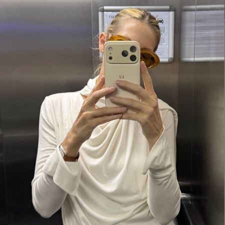 Kelly Rutherford takes a mirror selfie wearing a draped fine-knit jumper with oversized sunglasses.