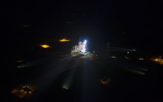 Space shuttle Atlantis lit up on launch pad