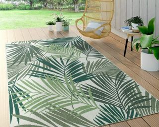 A tropical leaf pattern outdoor rug on decking