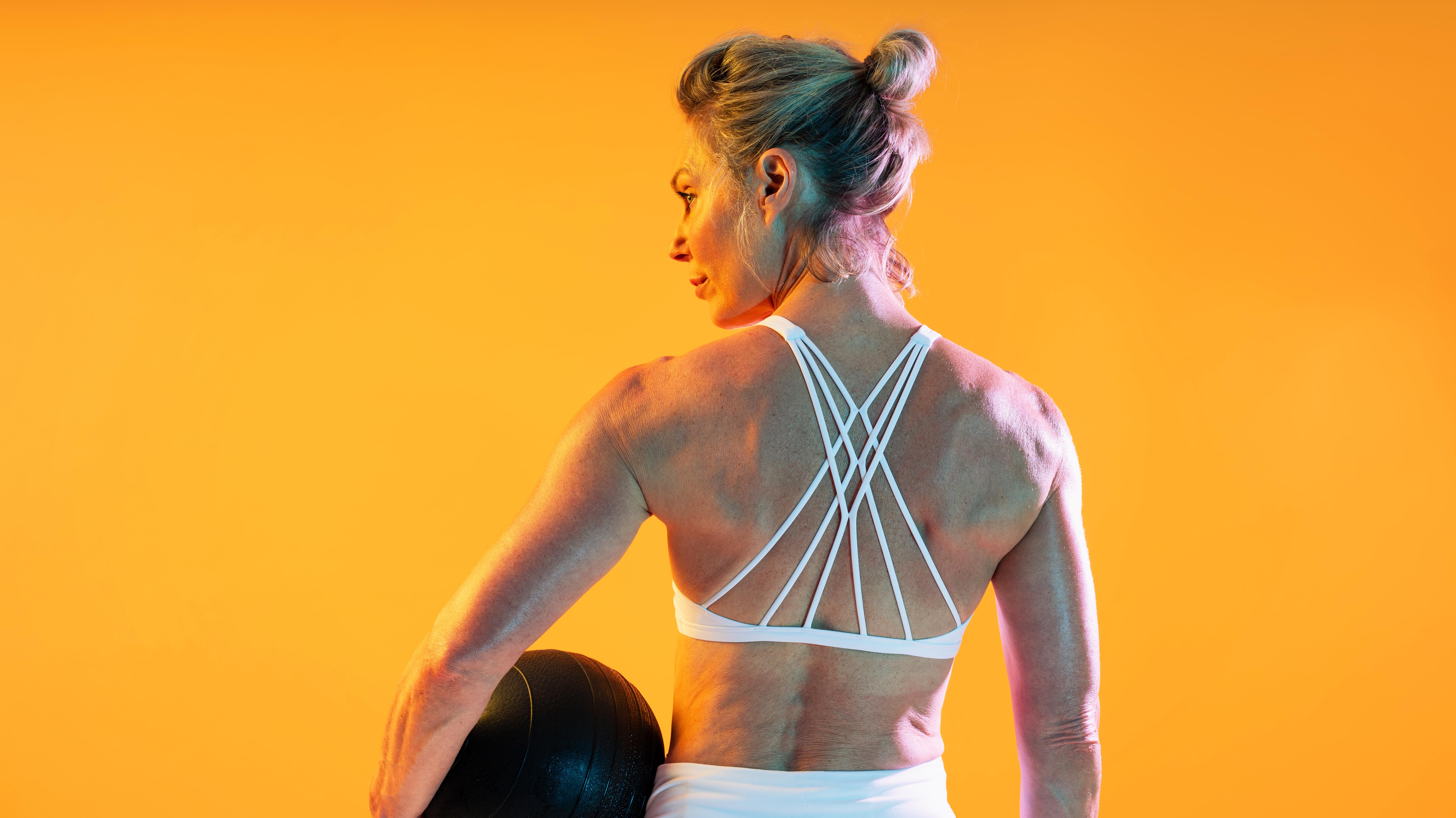 a senior woman holding a Pilates ball