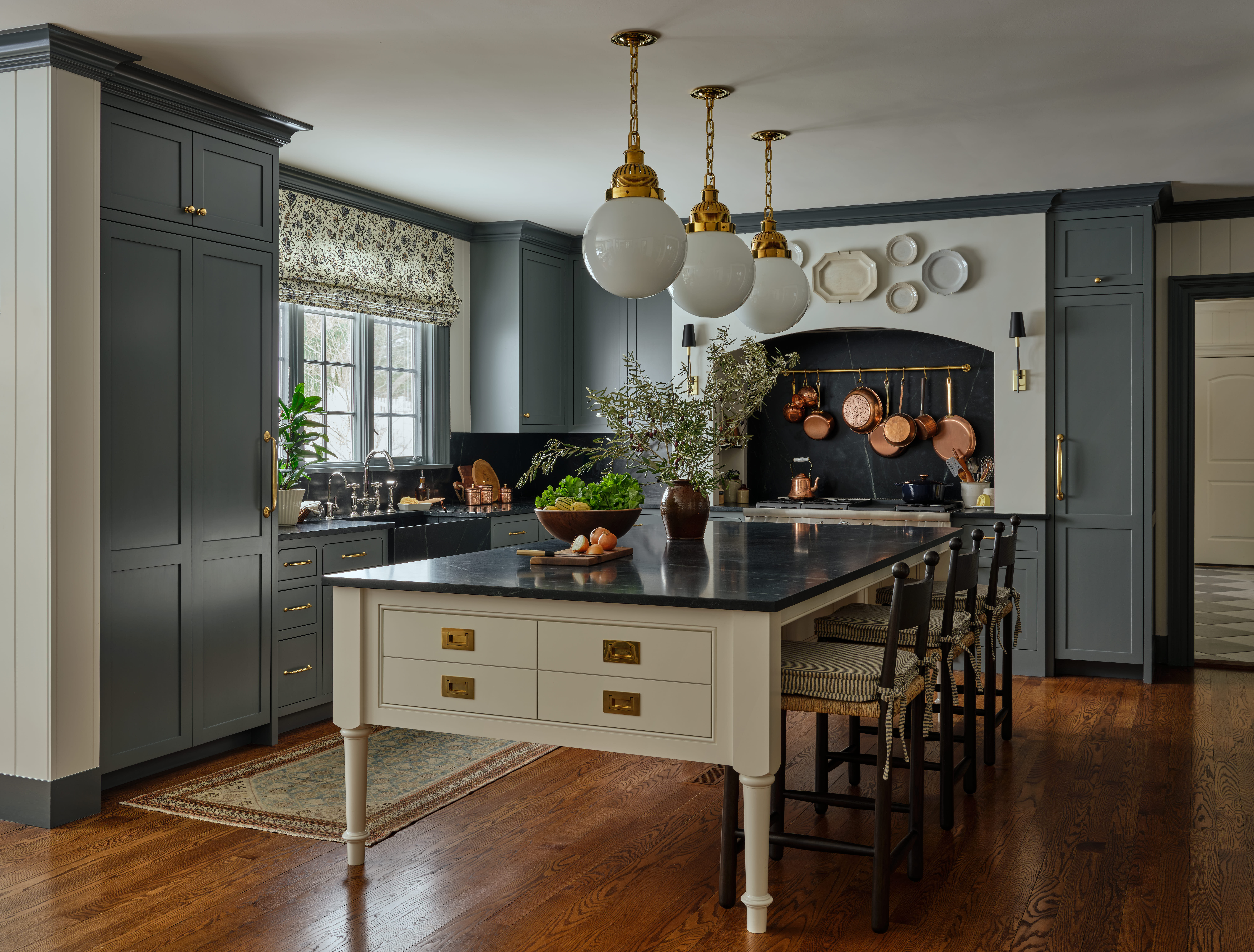 A traditional kitchen with dark gray cabinets and a white walls