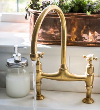 Kitchen with aged brass water faucet