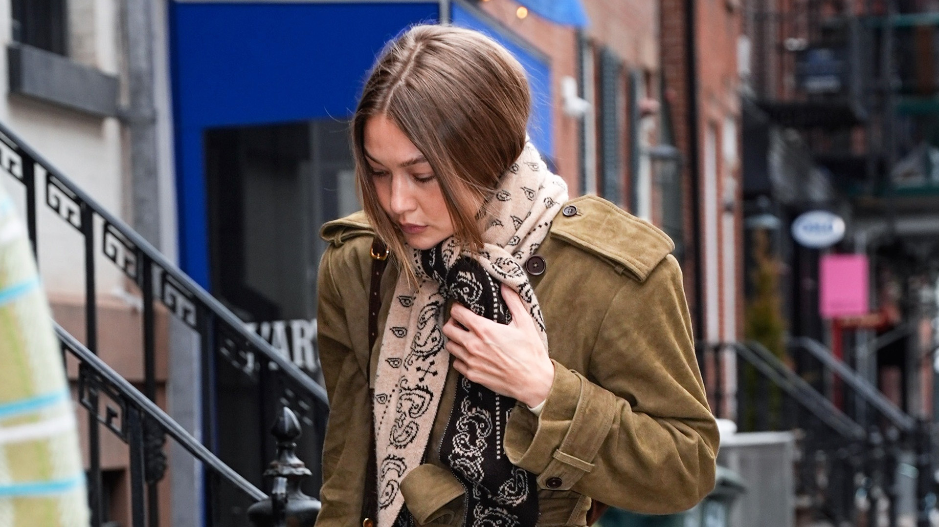 Gigi Hadid wearing a Guest in Residence Wild Rag scarf, suede Helsa coat, raw-hem jeans, and loafers in Manhattan