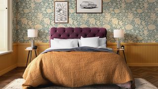 double bed with bedding and pillows in front of wall with floral wallpaper