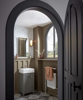 white geometric patterned wallpaper above mustard painted walls in downstairs cloakroom