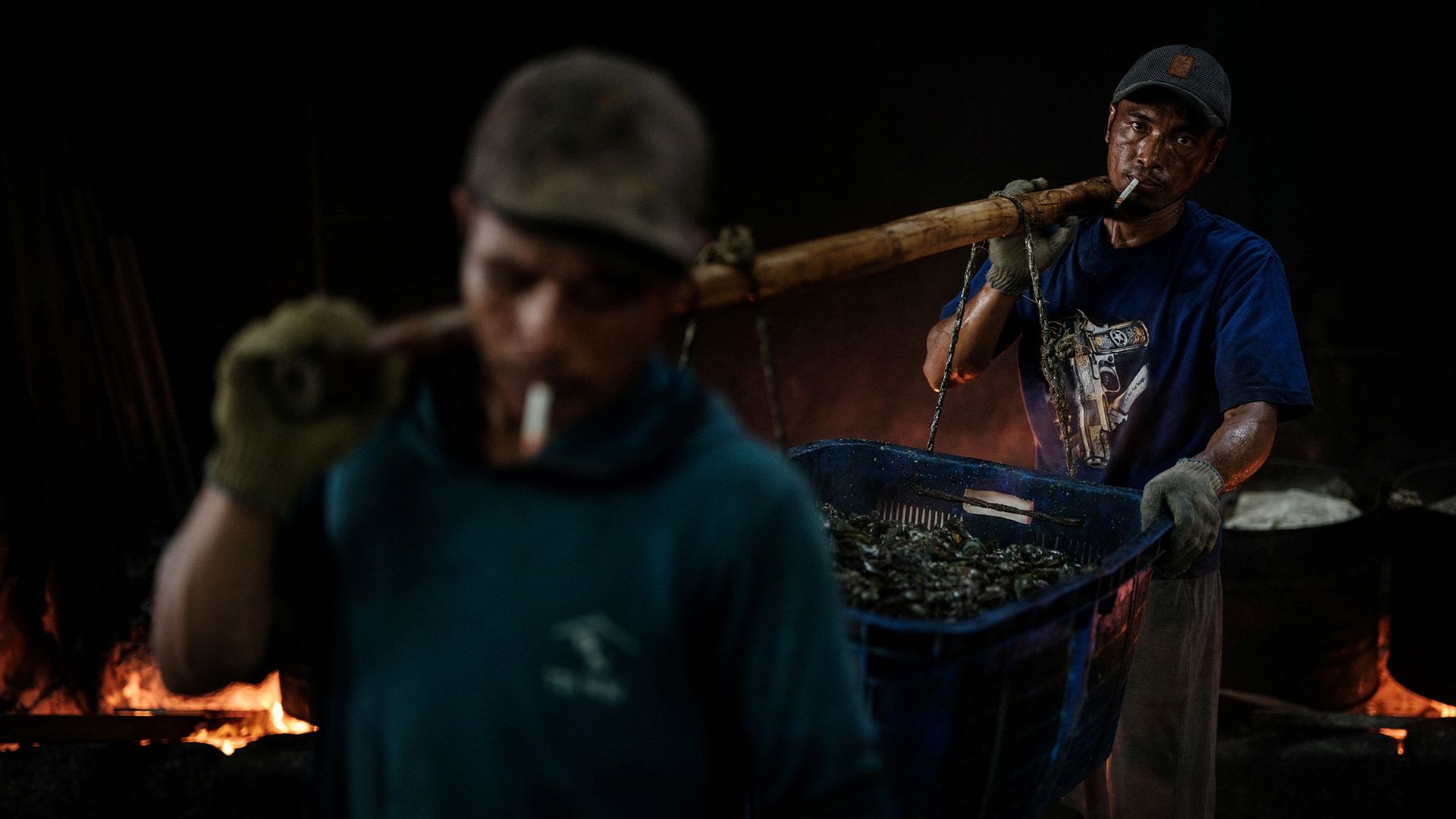 
                                Workers carry a basket of freshly boiled green mussels at a processing site in Cilincing, North Jakarta
                            