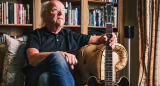 Martin Barre of Jethro Tull photographed at home in front of his bookshelf, with his pristine Gibson ES-330TD