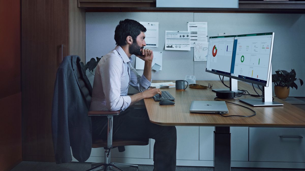 Man sat at desk looking at monitors