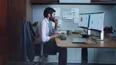 Man sat at desk looking at monitors