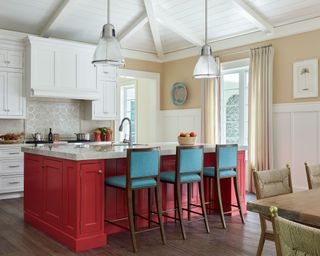 Traditional kitchen with red island and blue stools