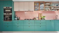 turquoise kitchen with drawers and pink tiled back splash