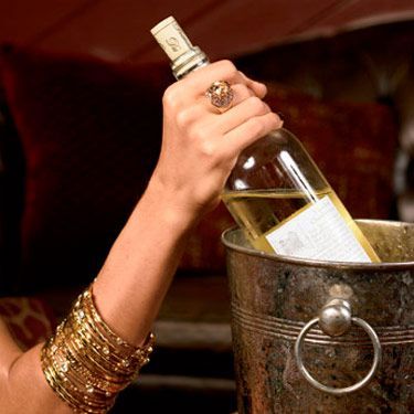 woman with bracelets removing wine from bucket