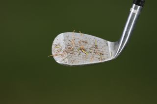 golf wedge face with dirt on it