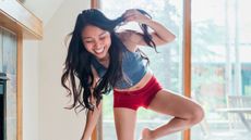 Smiling woman balancing on one leg